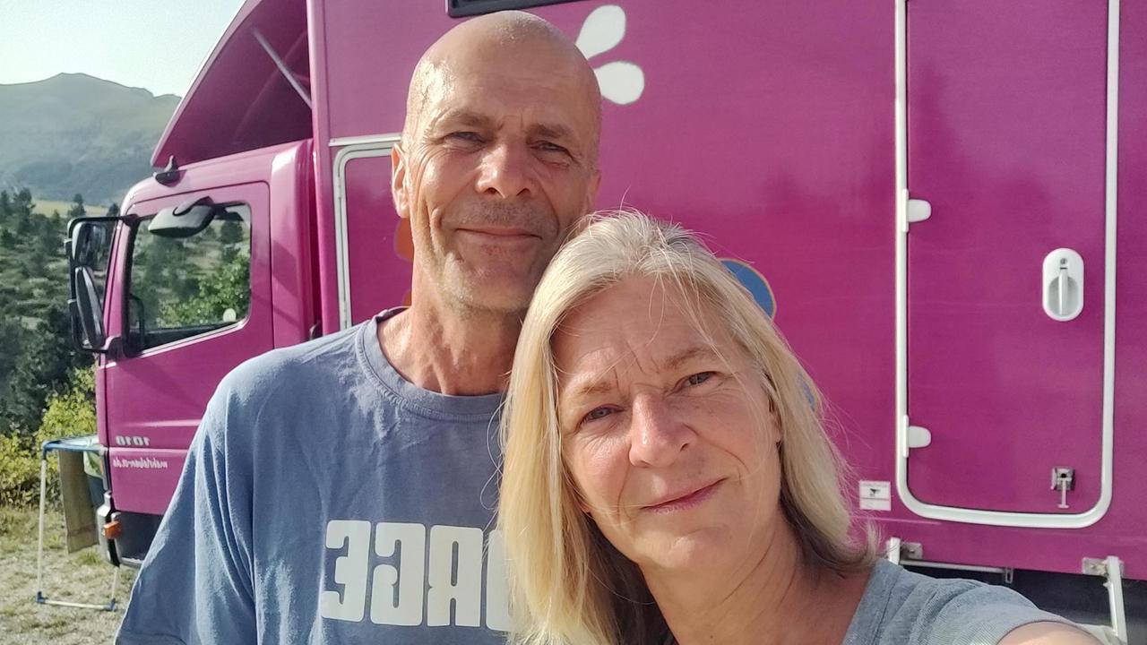 Porträt von Conny und Thomas vor ihrem rosa Camper-Van.