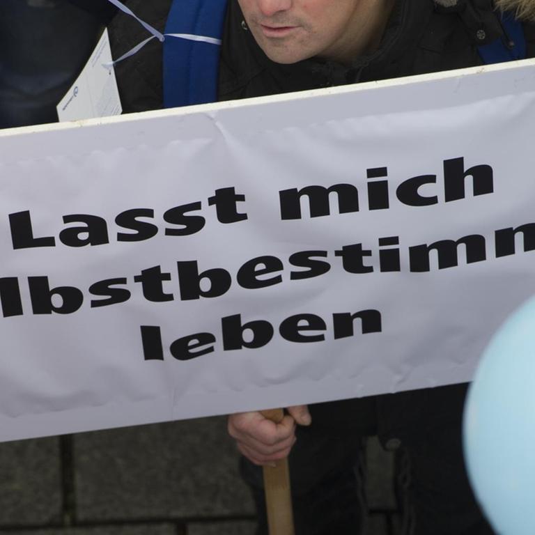 "Lasst mich selbstbestimmt leben" steht am 07.11.2016 in Berlin auf dem Plakat eines Demonstranten vor dem Brandenburger Tor. Die Bundesvereinigung "Lebenshilfe" hatte zu einer Demonstration aufgerufen, um ein besseres Bundesteilhabegesetz (BTHG) für Menschen mit Behinderung zu fordern. Derzeit befassen sich bundespolitische Gremien mit der künftigen Gestaltung des neuen BTHG. Foto: Paul Zinken/dpa ++