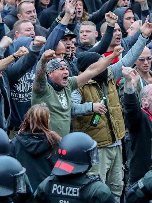In Chemnitz gestikulieren am 27.8.2018 Demonstranten der rechten Szene und drohen den Gegendemonstranten Gewalt an.