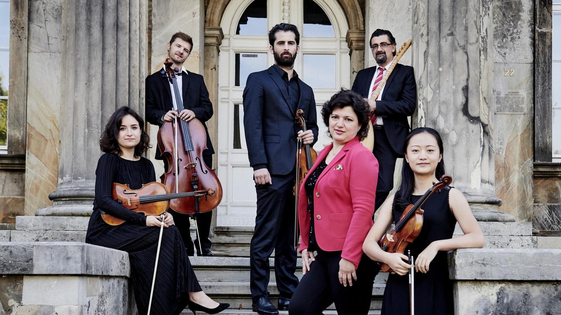 Komponistin Khadija Zeynalova und das Ensemble „Bridge of Sound“ stehen mit Ihren Instrumenten auf der Treppe des ehem. Fürstlichen Palais in Detmold. Komponistin Khadija Zeynalova und das Ensemble „Bridge of Sound“ stehen mit Ihren Instrumenten auf der Treppe des ehem. Fürstlichen Palais in Detmold.