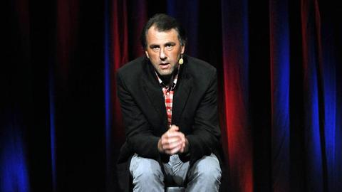 Der Komiker Stefan Waghubinger sitzt beim Köln Comedy-Festival auf der Bühne. 