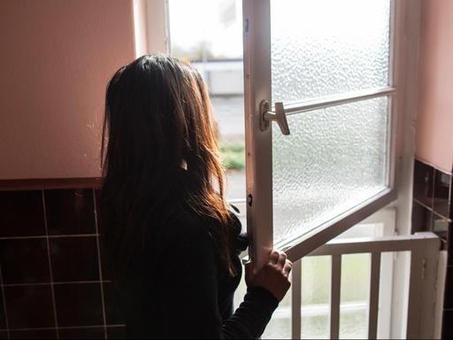 Eine Frau steht im Frauenhaus in Herne vor dem Fenster.