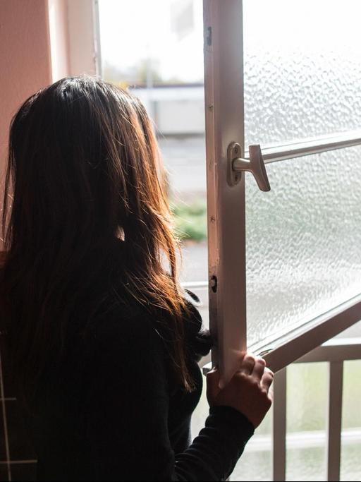 Eine Frau steht im Frauenhaus in Herne vor dem Fenster.