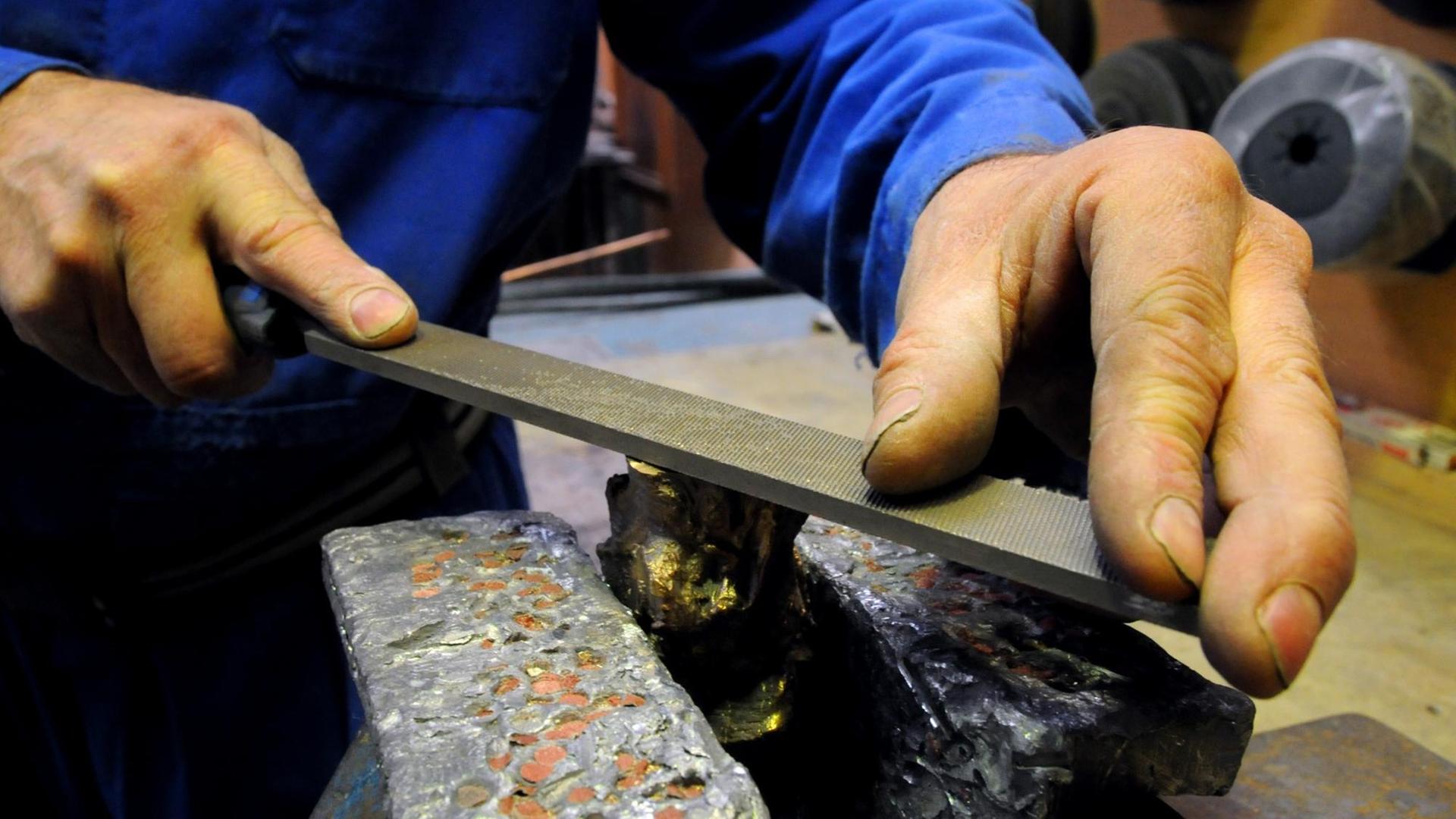 Symbolbild/ Metallbau: Ein Metallarbeiter arbeitet mit einer Metallfeile (Foto vom 08.02.2012). Foto: Horst Ossinger dpa