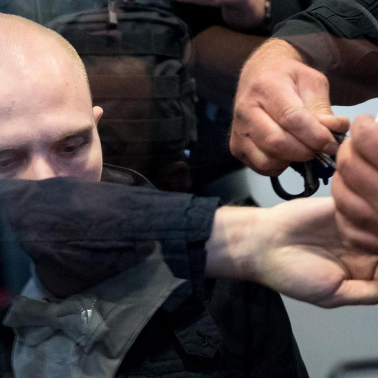 Dem angeklagten Stephan B. werden vor dem Landgericht in Magdeburg die Handschellen abgenommen. Der Attentäter hatte am 9. Oktober 2019 versucht, in der Synagoge in Halle ein Blutbad anzurichten.