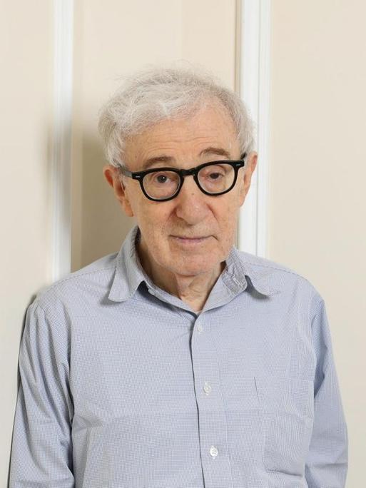 Der Filmemacher Woody Allen lehnt sich an die Wand in einer Zimmerecke.