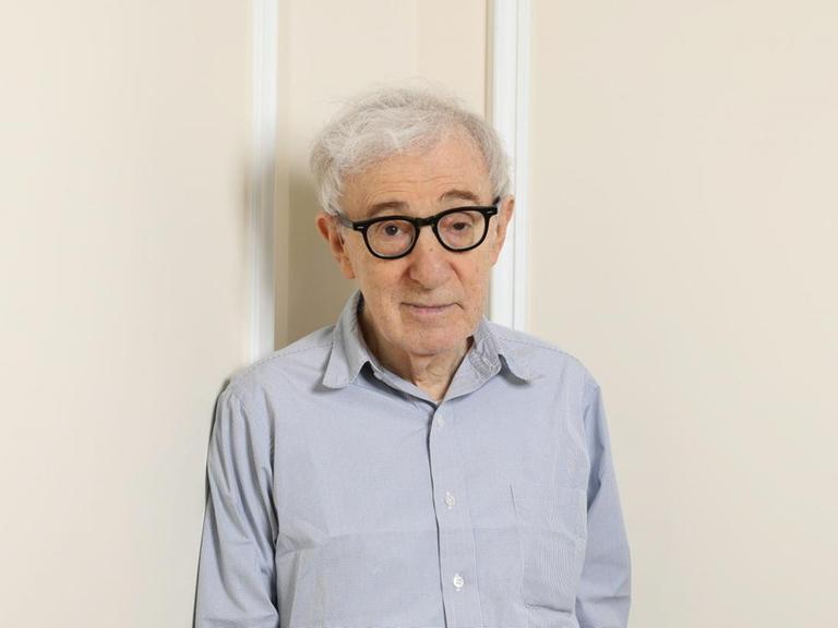 Der Filmemacher Woody Allen lehnt sich an die Wand in einer Zimmerecke.