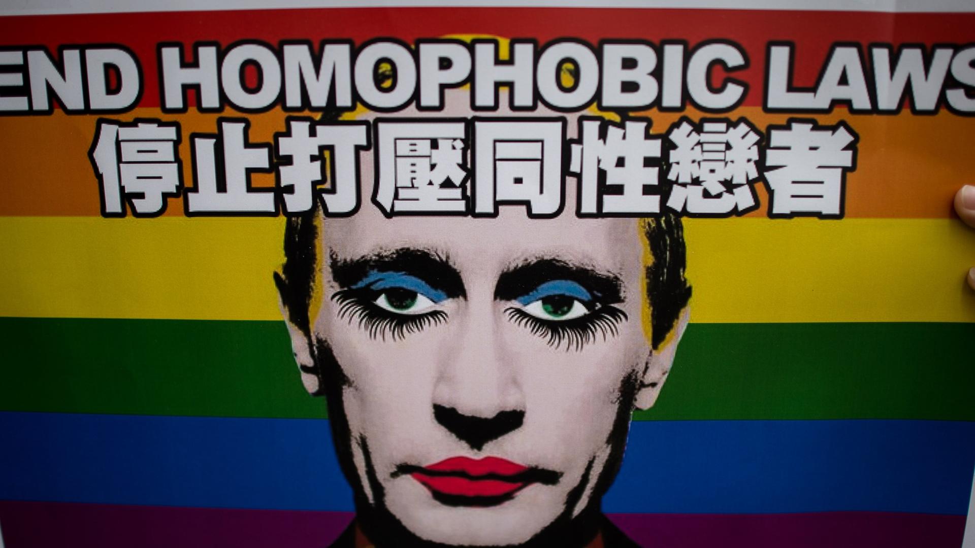 Ein Plakat mit der Aufschrift "End homophobic laws" zeigt einen wie eine Dragqueen geschminkten Wladimir Putin, im Hintergrund die Regenbogenflagge als Symbol der homosexuellen Bewegung.