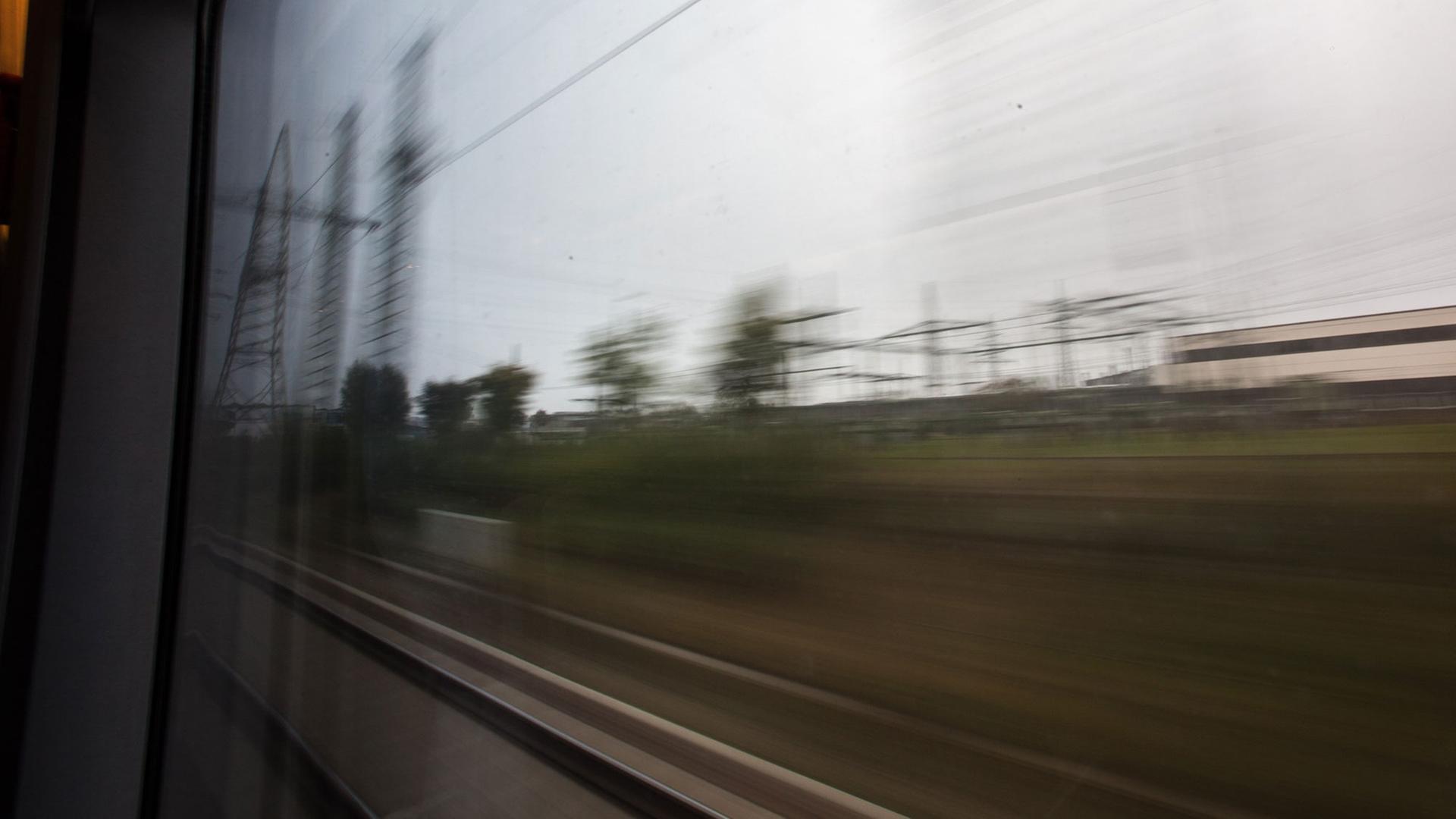 Der Blick aus dem Zugfenster zeigt eine verschwommene Landschaft. Aufgenommen in Köln am 30.09.2012.