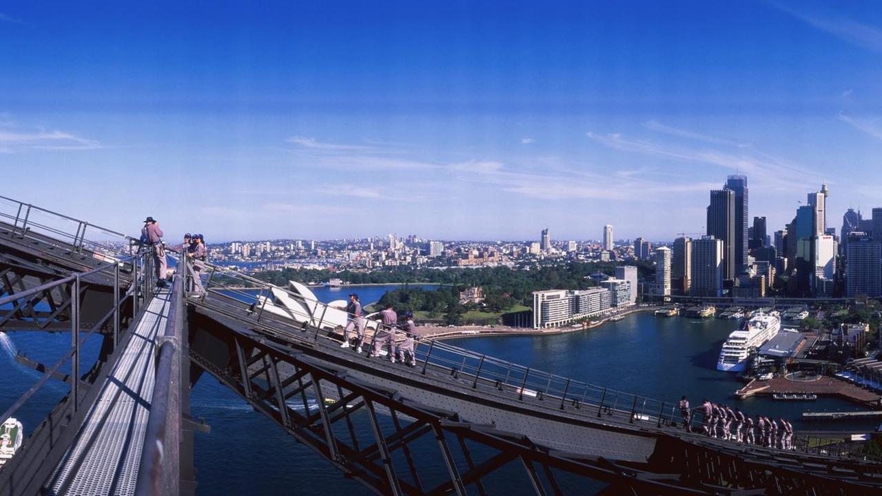 Leute klettern auf der Harbour Brigde, einem Wahrzeichen der Stadt Sydney.