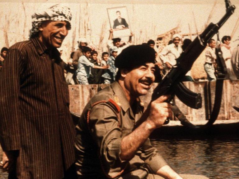 Saddam Hussein (r.), irakischer Diktator in einer Kampfpose vor dem Golf-Krieg 1990