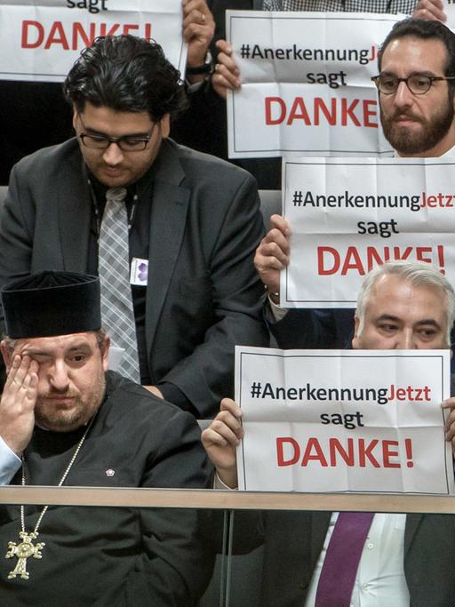 Mitglieder der Armenier-Initiative "Anerkennung Jetzt" halten im Bundestag in Berlin Schilder mit dem Schriftzug "Danke" hoch.