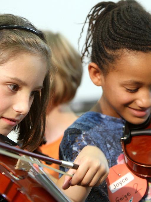 Zwei Grundschülerinnen aus Oberhausen probieren ihre neuen Geigen aus.