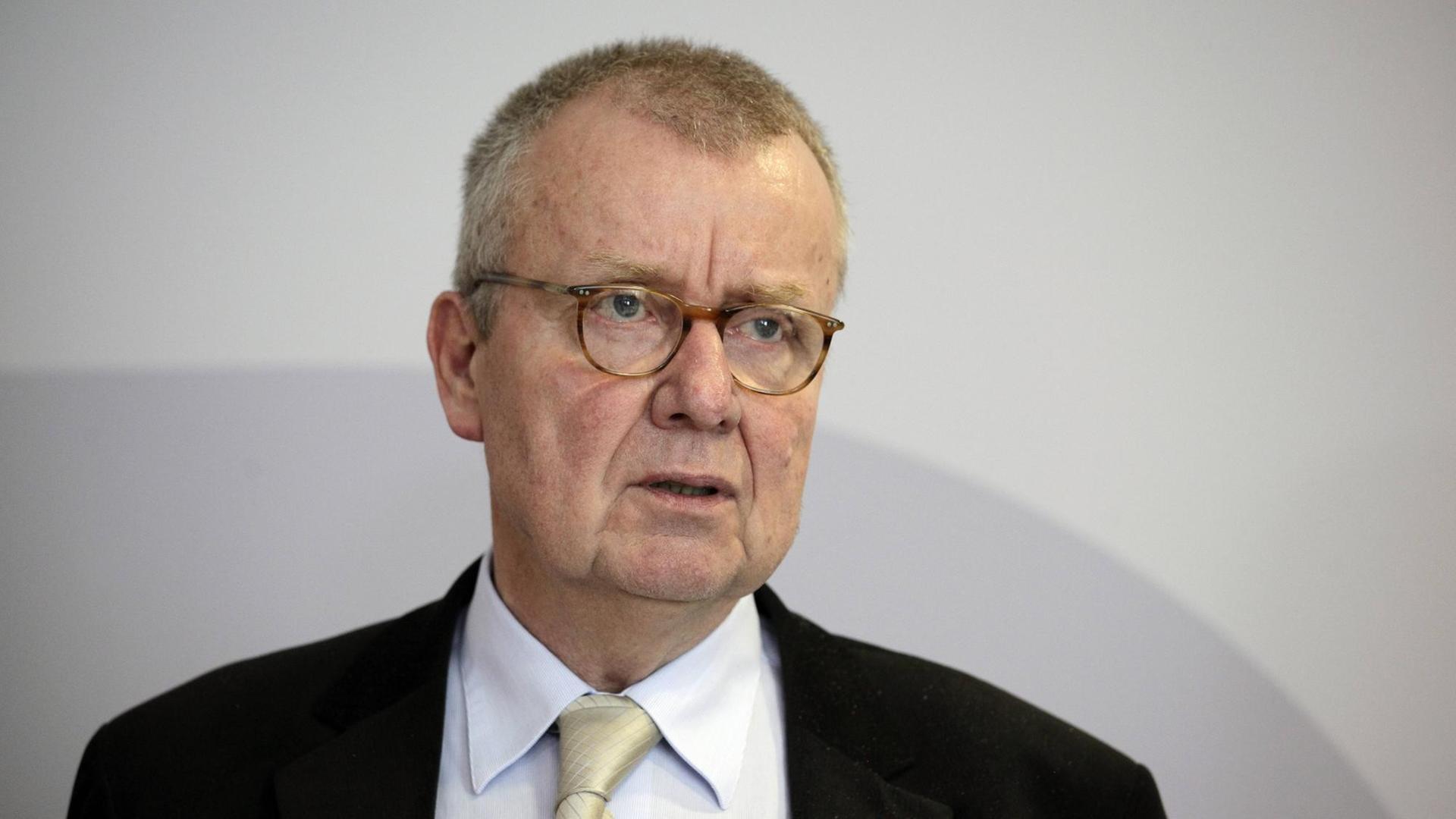 Ruprecht Polenz mit Brille, dunklem Sakko und weißem Hend. Er steht vor einer weißen Wand und sagt etwas.
