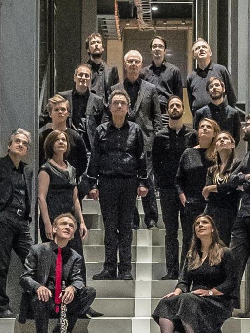 Das Ensemble hat sich auf einer Treppe in einem Konzerthaus versammelt