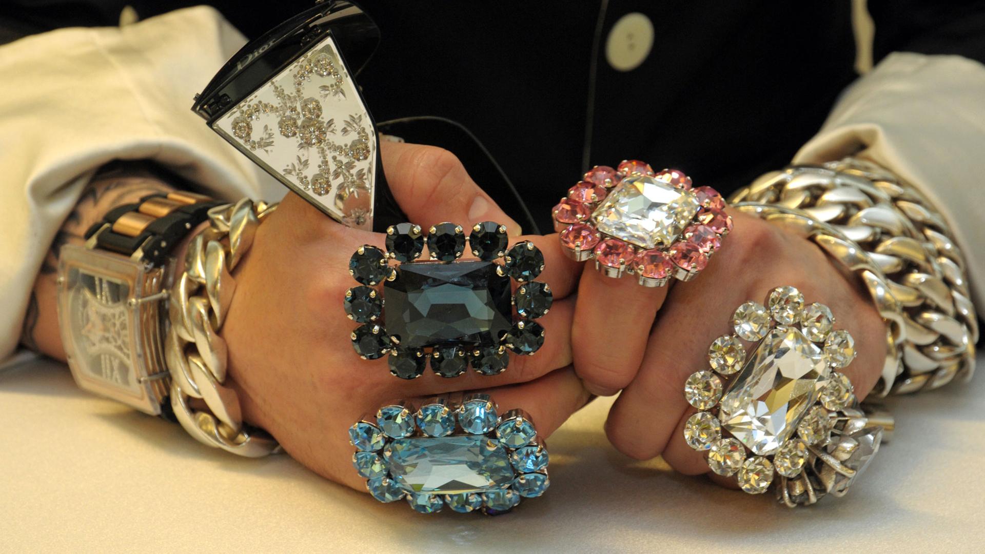 Modeschöpfer Harald Glööckler posiert am 01.09.2010 in Düsseldorf mit mehreren sehr großen glitzernden Ringen an beiden Händen und diversen Goldarmbändern bei der Präsentation des zweiten QVC-Senders "QVC Plus", wo er ab 2011 seine Mode verkauft. Modeschöpfer Harald Glööckler posiert am 01.09.2010 in Düsseldorf mit mehreren sehr großen glitzernden Ringen an beiden Händen und diversen Goldarmbändern bei der Präsentation des zweiten QVC-Senders "QVC Plus", wo er ab 2011 seine Mode verkauft.