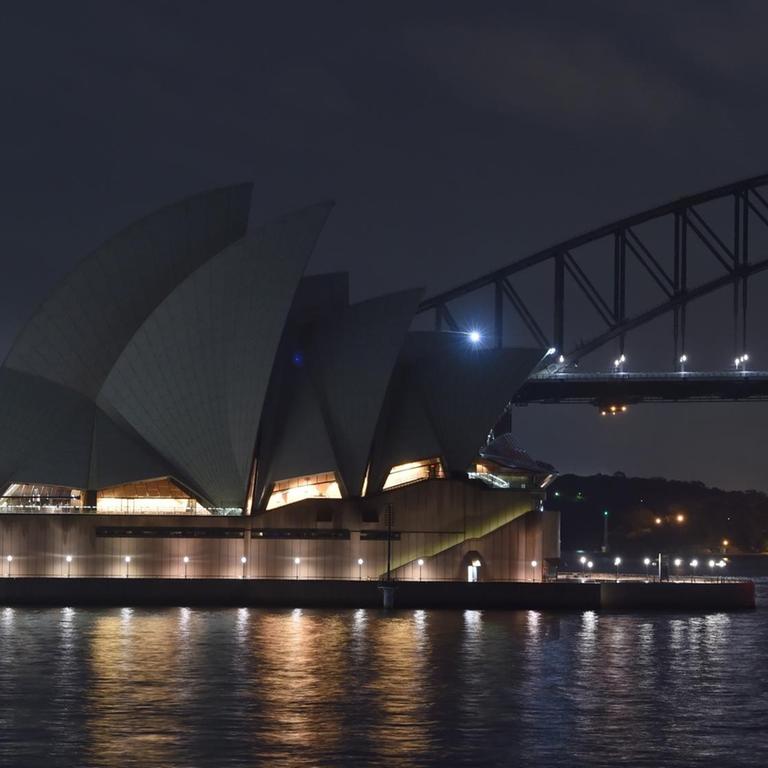 Das Opernhaus und die Hafenbrücke von Sidney liegen im Dunkeln