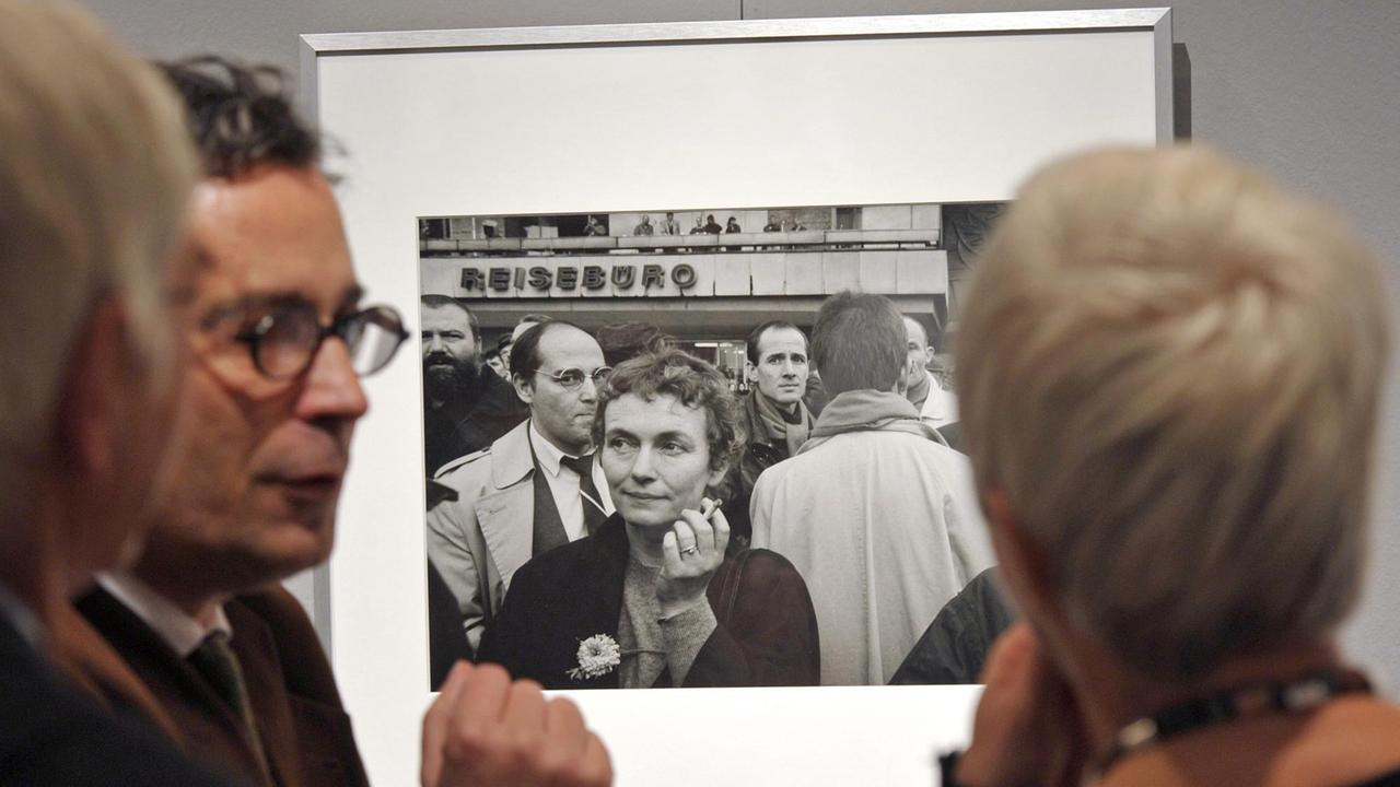 Besucher der Ausstellung "Blicke über die Mauer"betrachten eine Fotografie von Barbara Klemm.
