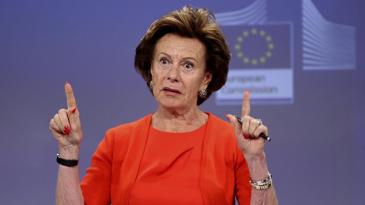 Die ehemalige EU-Wettbewerbskommissarin Neelie Kroes spricht an einem Rednerpult und gestikuliert mit den Händen.