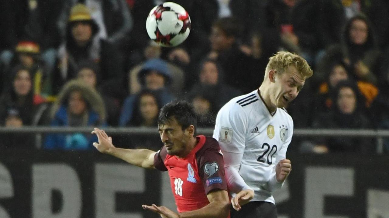 Das Bild zeigt eine Szene aus dem WM-Qualifikationsspiel Deutschland - Aserbaidschan. Zu sehen ist ein Kopfball-Duell zwischen Julian Brandt und Tamkin Khalilzade.