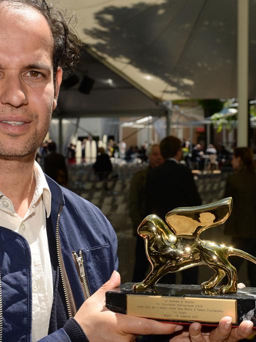 Der deutsche Künstler Tino Sehgal posiert am 01.06.2013 in Venedig (Italien) mit dem Goldenen Löwen, dem "Golden Lion" für den besten Künstler in der Internationalen Ausstellung.