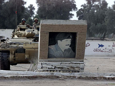 Britische Soldaten zerstören mit ihrem Panzer ein Bild Saddam Husseins in Basra am 24.3.2003