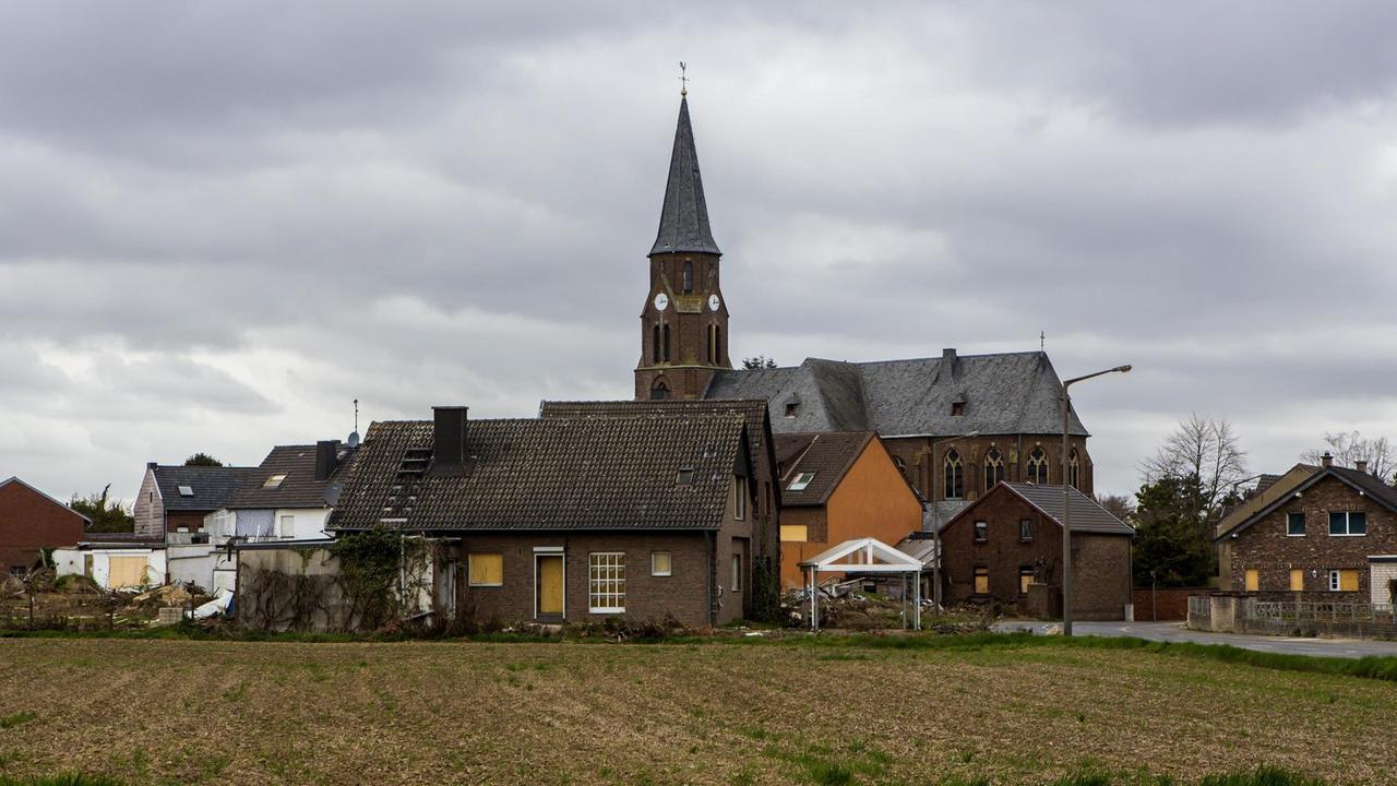 Verlasse Häuser im Geisterdorf Manheim, über deren Dächern ein Kirchturm aufragt.
