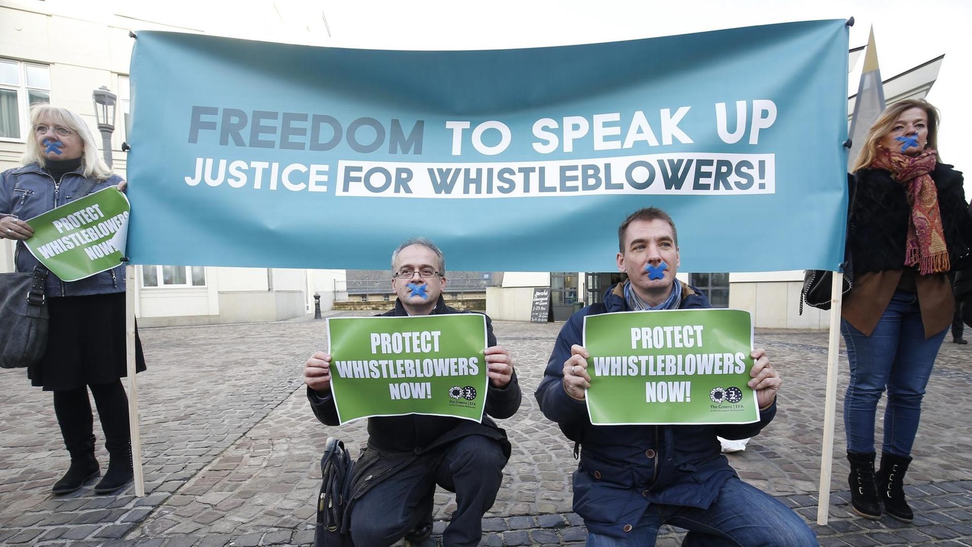 People hold placards 'Freedom to Speak Up, Justice for Whistleblowers!' and 'Protect Whistleblowers Now' during a demonstration at the start of the so-called LuxLeaks Whistleblower appeal trial, in the criminal court in Luxembourg, 12 December 2016. Three men, two former employees of accounting firm PricewaterhouseCoopers (PwC) Antoine Deltour and Raphael Halet and a journalist Edouard Perrin were on trial for leaking thousands of confidential documents revealing corporate tax deals. The court on 29 June 2016 handed suspended sentences to Antoine Deltour and Raphael Halet, while journalist Edouard Perrin was acquitted of all charges.
