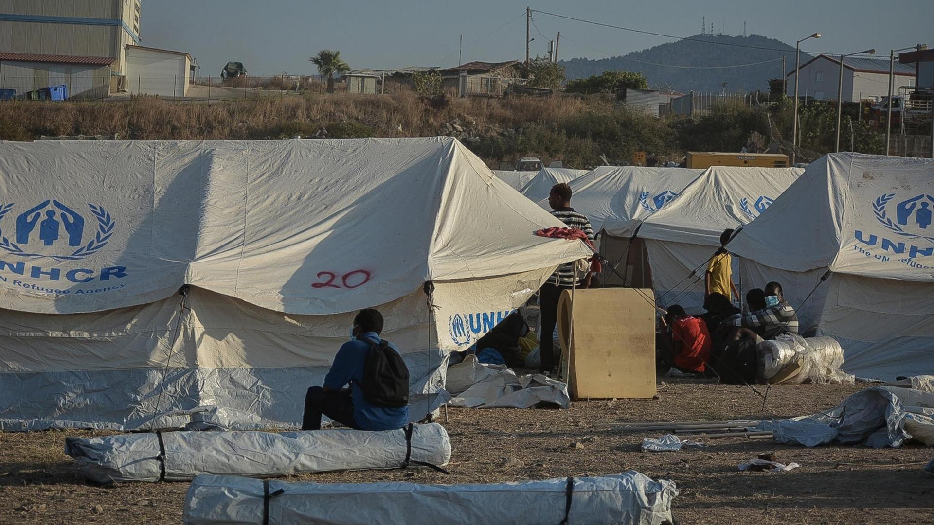 Geflüchtete sitzen und stehen zwischen UNHCR-Zelten im neuen vorübergehenden Aufnahmelager für Flüchtlinge in Kara Tepe auf der griechischen Insel Lesbos am Samstag, den 12. September 2020.