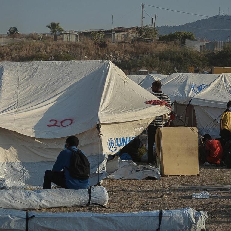 Geflüchtete sitzen und stehen zwischen UNHCR-Zelten im neuen vorübergehenden Aufnahmelager für Flüchtlinge in Kara Tepe auf der griechischen Insel Lesbos am Samstag, den 12. September 2020. 