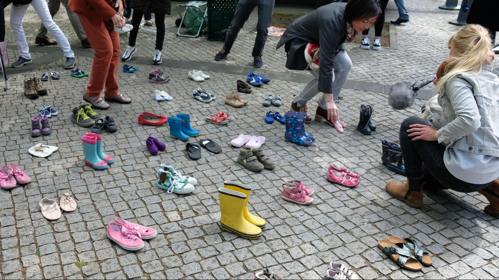 Niedersachsen, Hannover: Mitglieder der Initiative "Kinder von Lügde" verteilen vor dem Landtag in Hannover Kinderschuhe.