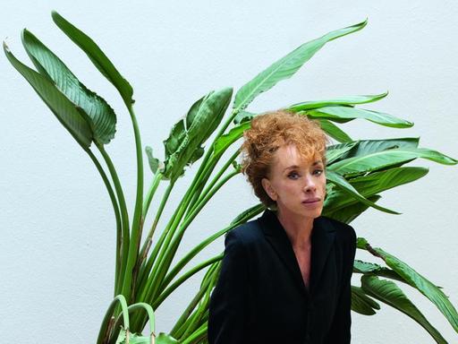 Porträtaufnahme von Sibylle Berg vor einer Zimmerpflanze.