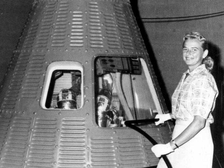 Jerry Cobb posiert neben einer Mercury Raumkapsel. Sie war eine TeilnehmerInnen des First Lady Astronaut Trainees (FLAT).