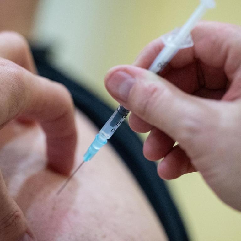 Ein Mann wird in Sindelfingen einem Altenpflegeheim von einem Mitglied eines Mobilen Impfteams des Klinikum Stuttgart mit einer Dosis eines Covid-19 Impfstoffes geimpft.