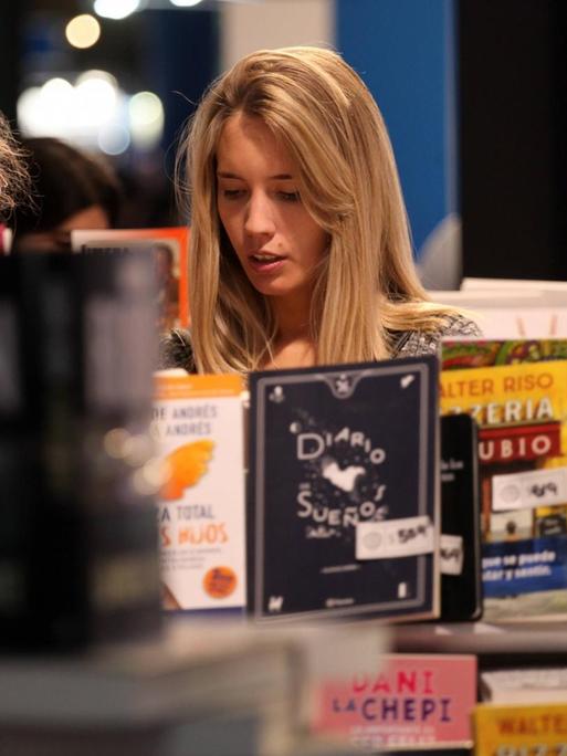 Zwei Frauen betrachten an einem Buchstand ein Buch während der Buchmesse in Buenos Aires 2019.