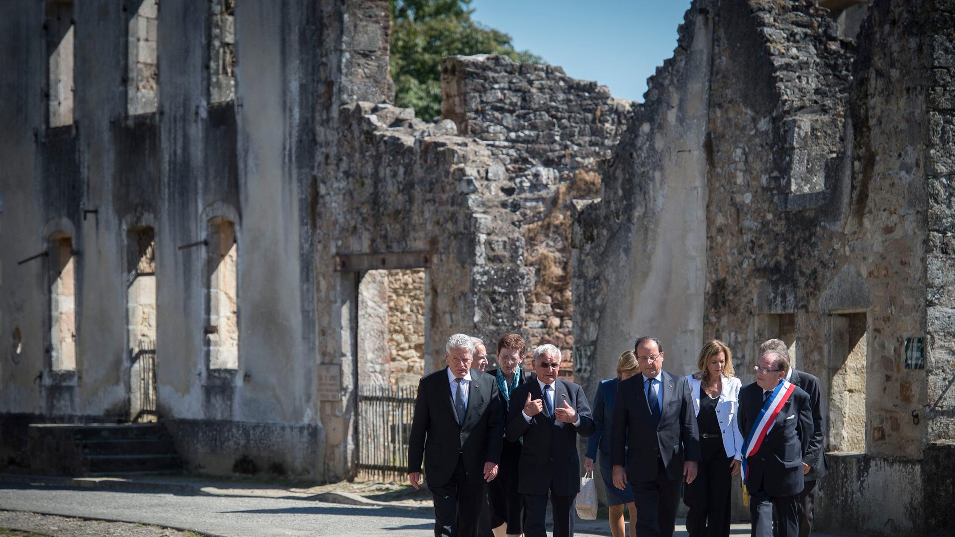 Bundespräsident Joachim Gauck, Robert Hébras, Überlebender des Massakers vom 10.Juni 1944, der französische Staatspräsident Francois Hollande und Raymond Frugier, Bürgermeister von Oradour, gehen durch das Dorf der Märtyrer