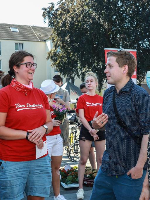 Kevin Kühnert spricht beim Straßenwahlkampf mit potenziellen SPD-Wählern