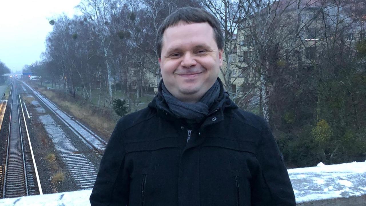 Der Berliner Historiker Sven Schultze steht auf einem Bahnübergang