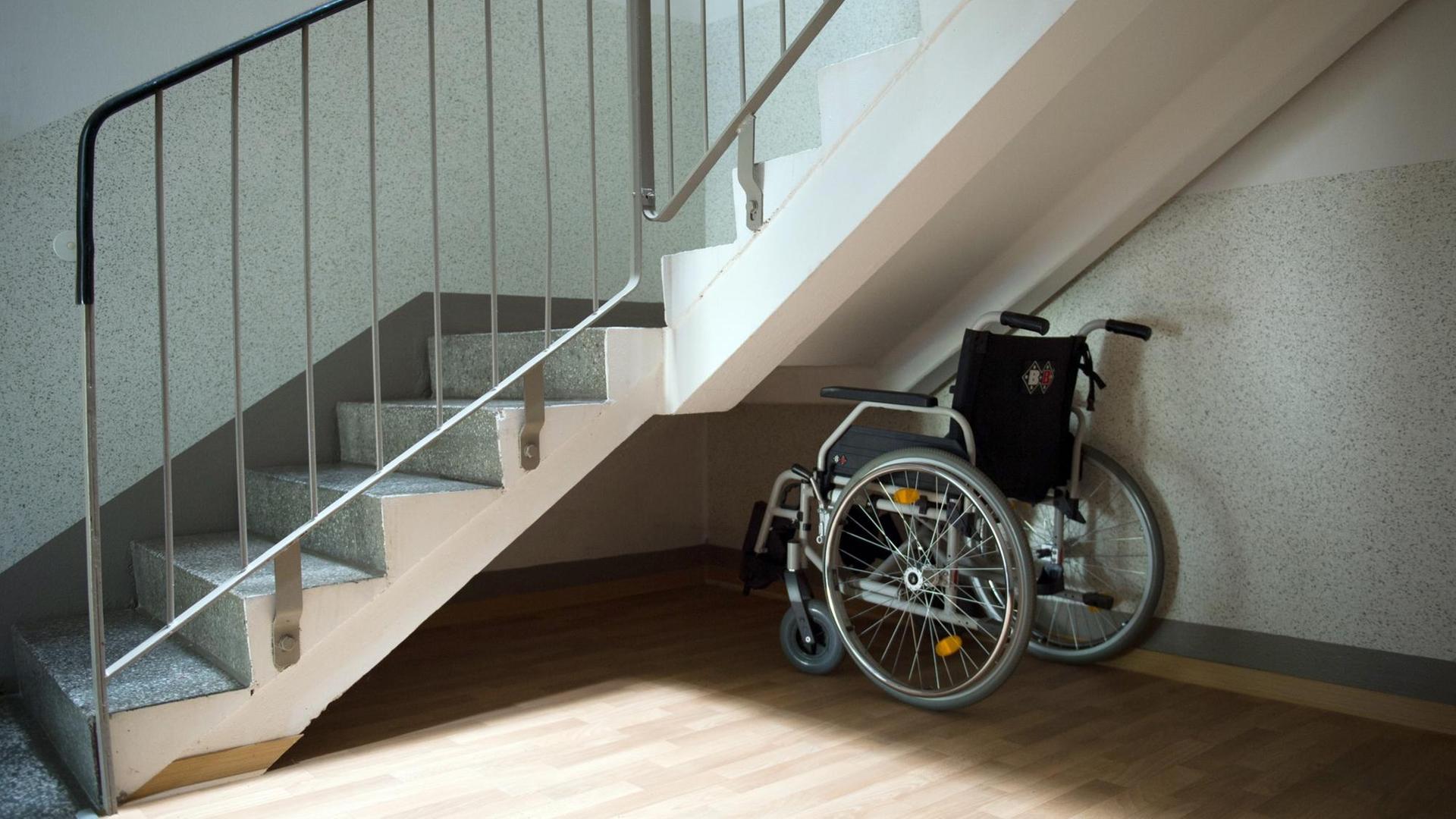 Ein Rollstuhl steht unter einer Treppe in einem Wohnhaus. Ein Rollstuhl steht unter einer Treppe in einem Wohnhaus.