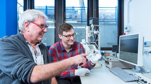 Kleiner Stein, riesige Erkenntnis: Die Planetologen Addi Bischoff (links) und Markus Patzek mit dem Meteoriten „Flensburg“ vor dem Rasterelektronenmikroskop