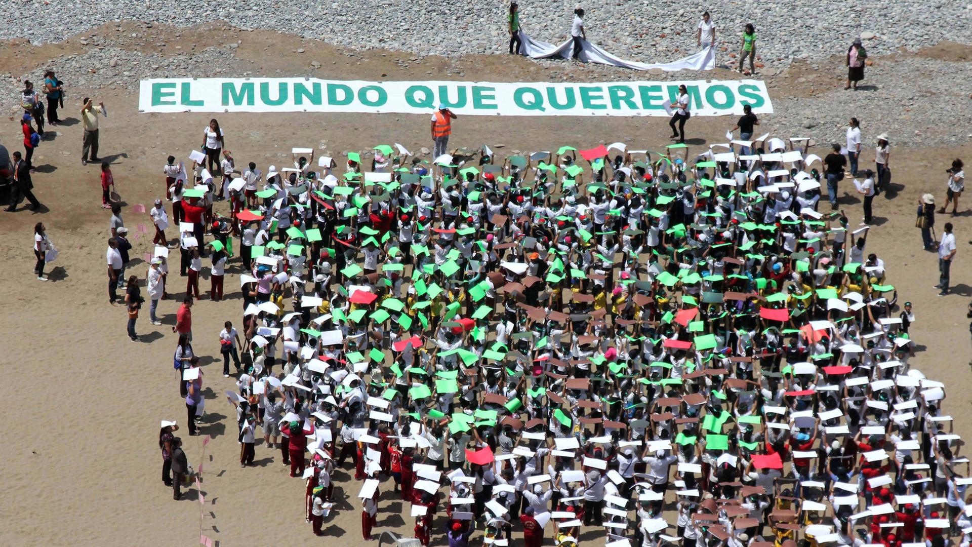 700 Kinder bilden die Form eines Baumes, über dem steht: "Die Welt, die wir wollen" am Strand von Lima, Peru. Hier findet der UN Klimagipfel statt.
