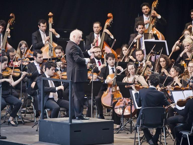 Das Foto zeigt Daniel Barenboim mit dem West-Eastern Divan Orchestra bei einem Konzert in der Berliner Waldbühne.