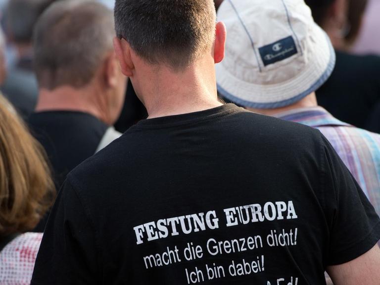 Ein Anhänger der islamfeindlichen Pegida-Bewegung trägt am 20.06.2016 ein T-Shirt mit dem Aufdruck "Festung Europa macht die Grenzen dicht. Ich bin dabei! Danke Tatjana & Ed!".