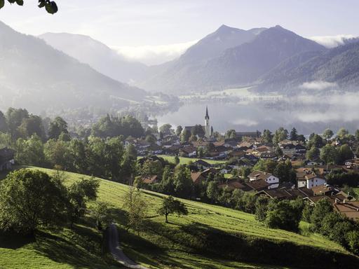 Morgennebel über Landschaft und Ort am Schliersee in Oberbayern