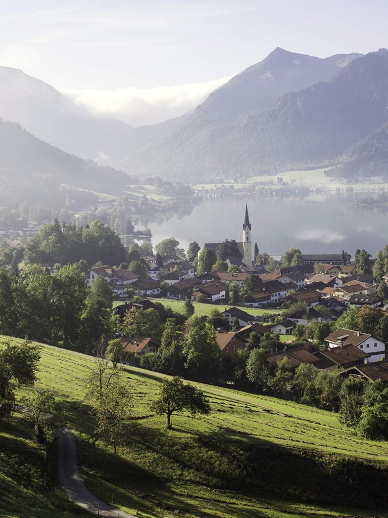 Morgennebel über Landschaft und Ort am Schliersee in Oberbayern