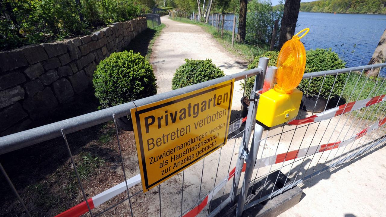 Ein Zaun mit Hinweisschild der Grundstückseigentümer hindert Passanten am Betreten des Uferwegs um den Griebnitzsee in Potsdam