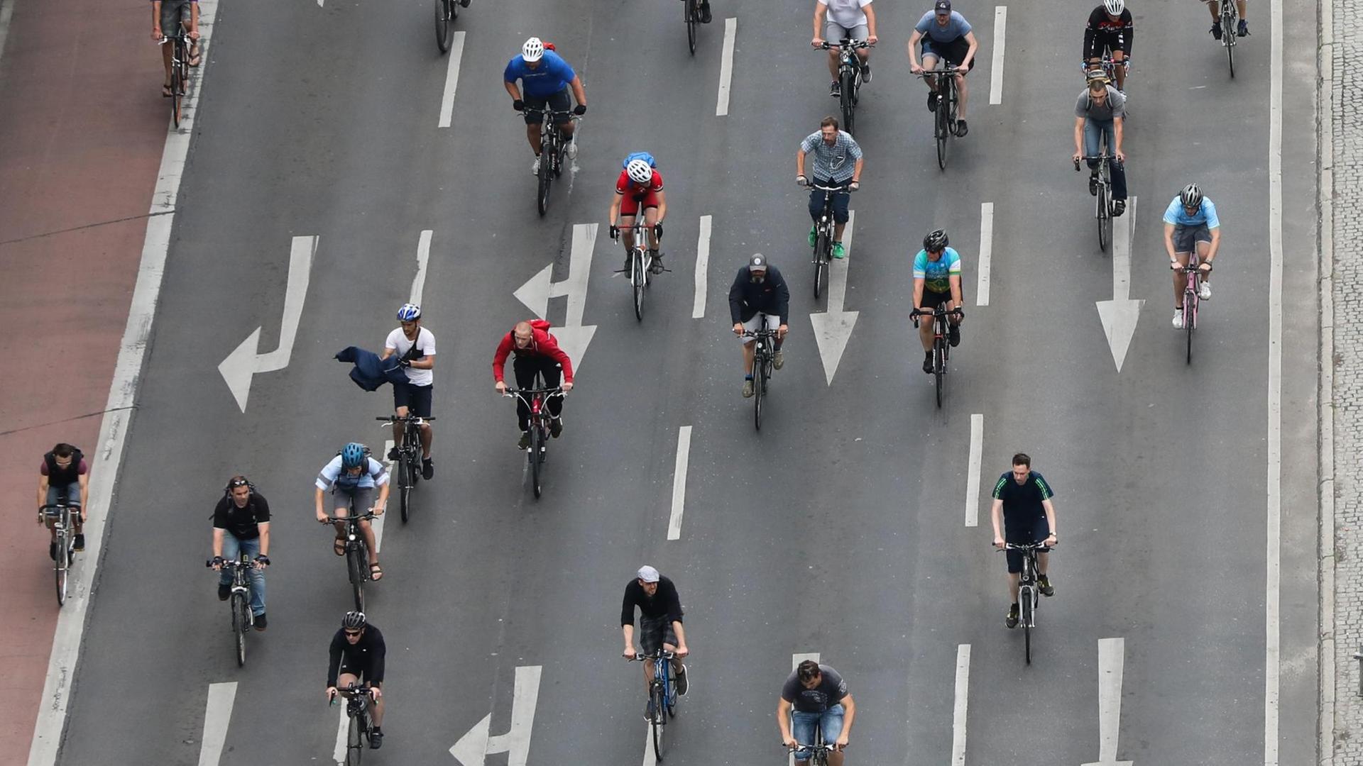Blick aus der Luft auf viele Radfahrer, die auf einer mehrspurigen Straße fahren. Blick aus der Luft auf viele Radfahrer, die auf einer mehrspurigen Straße fahren.
