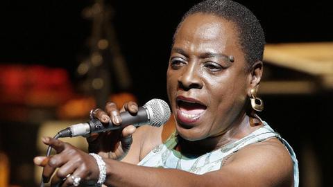 Die Sängerin Sharon Jones mit einem Mikrophon in der Hand bei einem Auftritt im Jahr 2014.