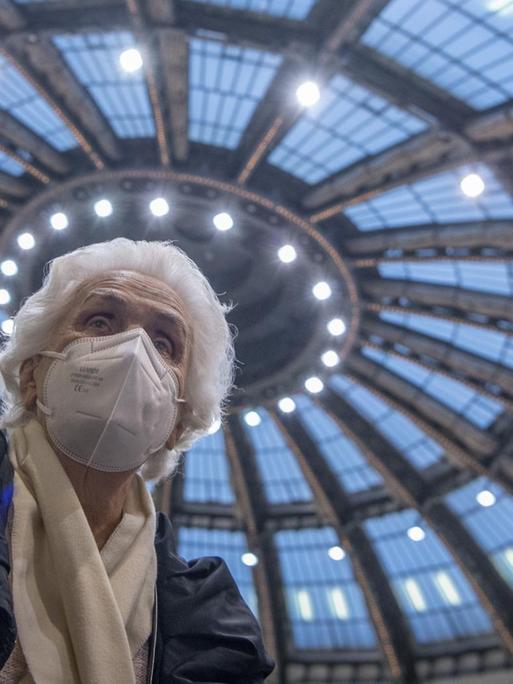 Nachdem sie ihre Impfung gegen das neuartige Coronavirus erhalten hat, sitzt die 90-jährige Odores H. unter dem Kuppeldach des Impfzentrums in der Festhalle in Frankfurt.