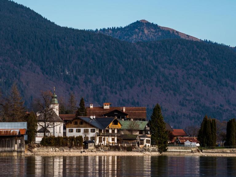 Teile der Ortschaft Walchensee (Bayern) spiegeln sich am 24.12.2014 unter blauem Himmel im gleichnamigen See.